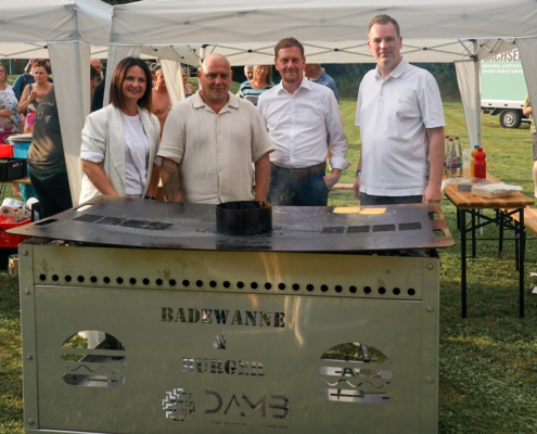 Ministerpräsident Michael Kretschmer (2.v.r.) und die regionale Landtagsabgeordnete Susan Leithoff (links) freuen sich über den Grill, den DAMB-Geschäftsführer Olaf Zachert (rechts) dem Freibad Sachsenburg sponsert.